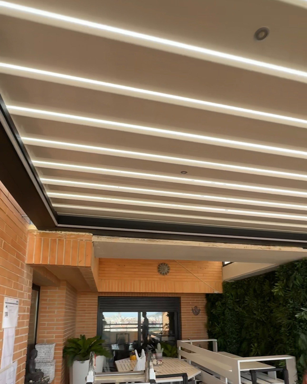 Iluminación LED encendida en la pérgola bioclimática de un ático de Alicante