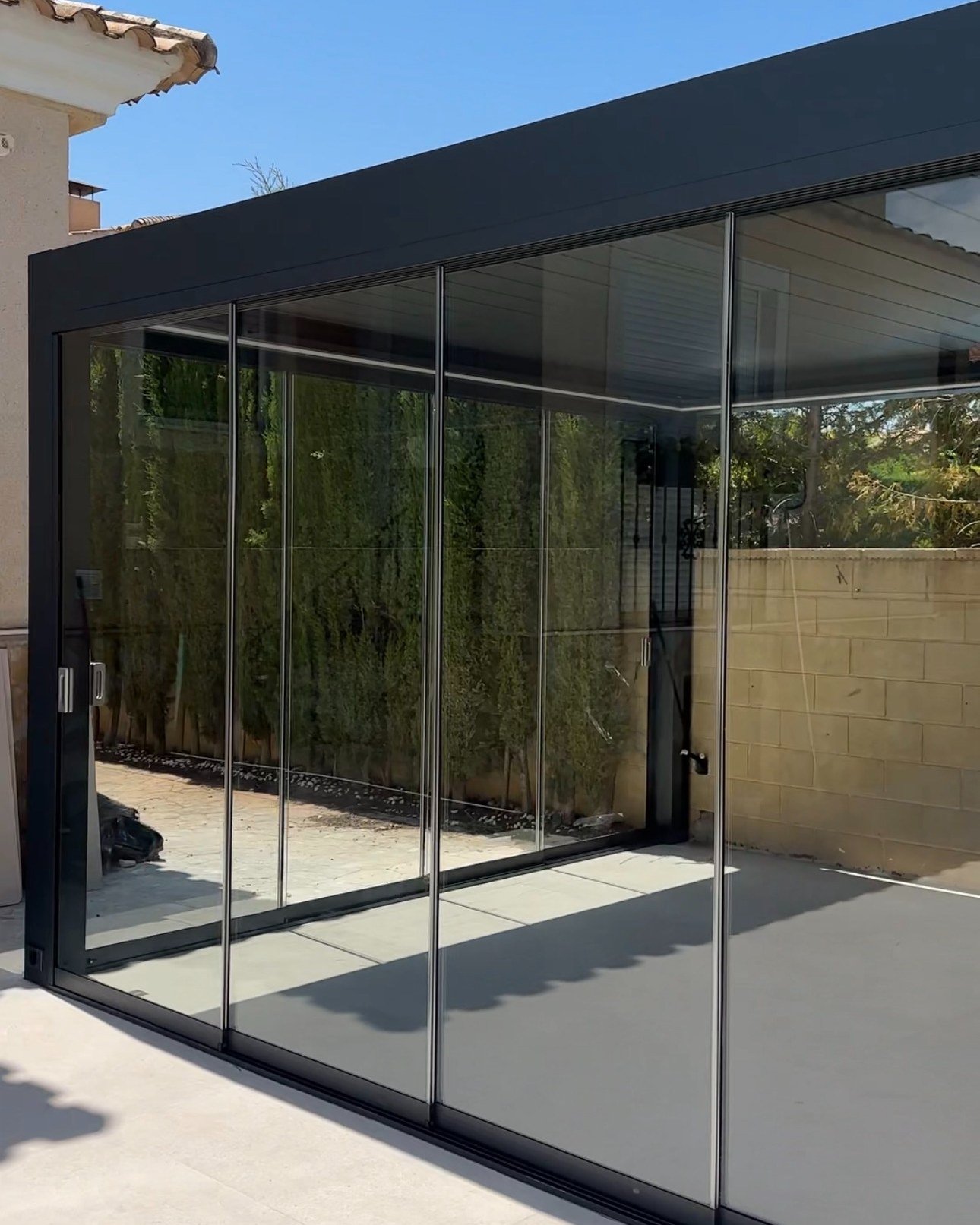 Lateral de una pérgola bioclimática cerrado con cortinas de cristal en Elche