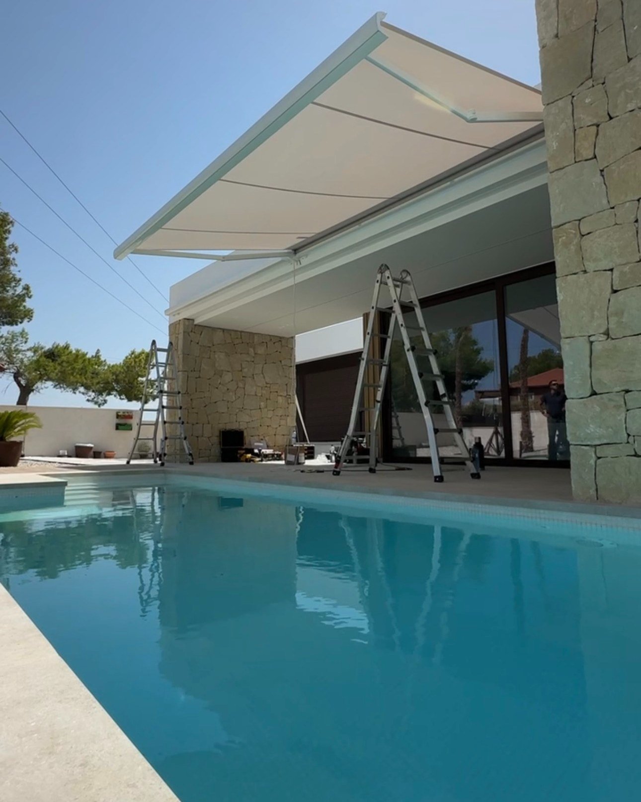 Toldo extensible sobre la fachada de piedra de un chalet