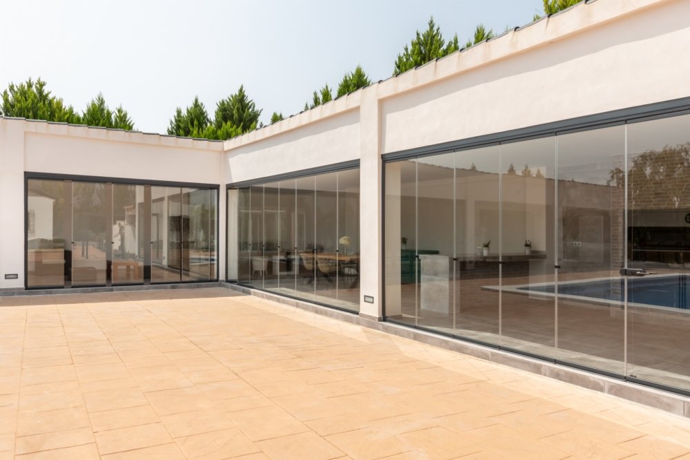 Instalación de cortinas de cristal abatibles en una terraza moderna, creando un espacio luminoso y protegido con vistas panorámicas al exterior." Este conjunto de metadatos no solo mejora la visibilidad de la imagen en los motores de búsqueda, sino que también describe el producto de manera precisa y atractiva para usuarios y clientes.