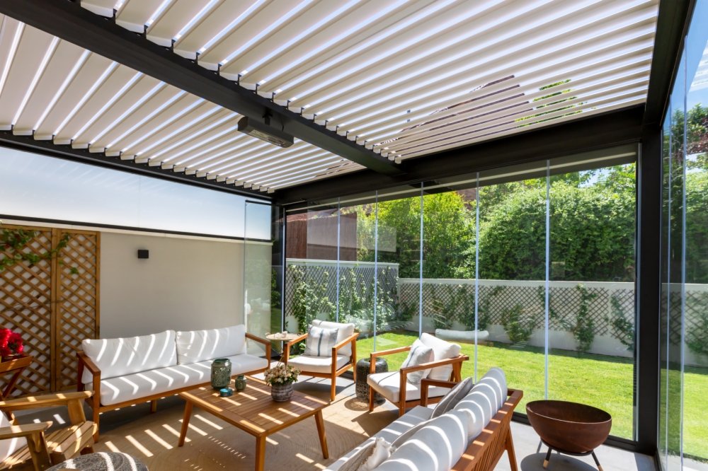 Moderna pérgola bioclimática con lamas orientables y cerramiento de cristal abatible en una terraza privada, creando un espacio acogedor y protegido para disfrutar todo el año." Con este conjunto de metadatos, tu imagen será más relevante para las búsquedas relacionadas con pérgolas bioclimáticas, cerramientos y lamas móviles, lo que puede mejorar su posicionamiento en los motores de búsqueda